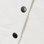 closeup-of-snap-button-detail-on-white-leather-mini-skirt